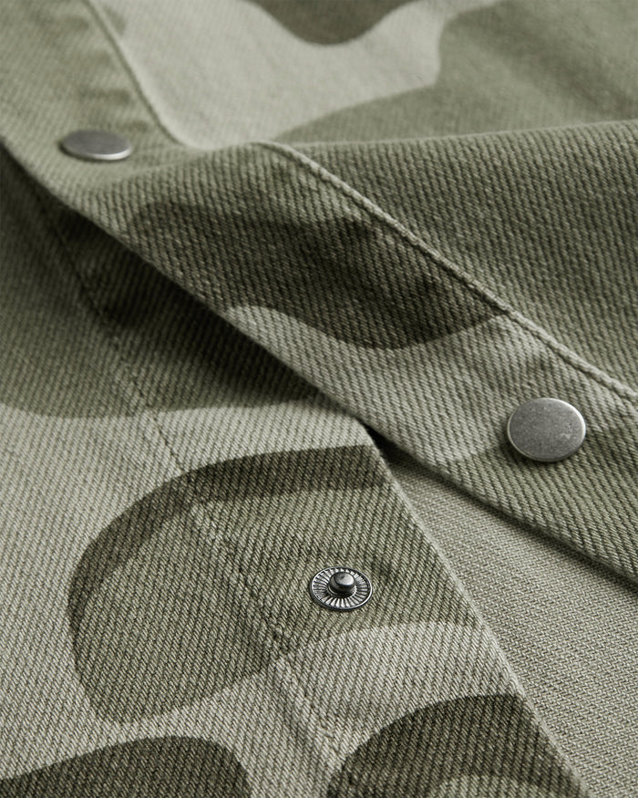 The Bilbao Overshirt in camo — close-up of the metal snap buttons and twill texture
