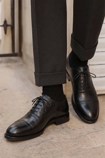 Creed black leather men's brogue shoes with a classic five-eyelet toecap design, featuring polished finish and timeless sophistication