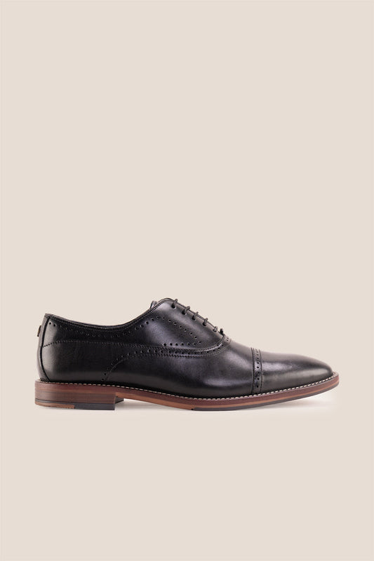 Premium men's black leather oxford shoes by Oswin Hyde London, featuring a cap toe with decorative perforations, closed lacing, contrast welt stitching, and a cushioned teal interior.