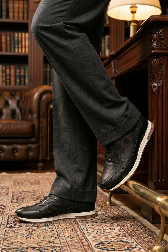 Model wearing Colt black men's leather sneakers with elastic detailing for a secure, comfortable fit and sleek, modern style
