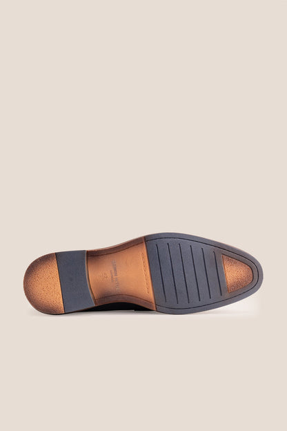 Premium black leather tassel loafers for men featuring a textured finish, burnished moc-toe details, decorative leather tassels, and a cushioned teal interior.