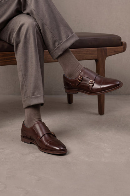 Model wearing Kayden Brown leather monk strap shoes by OSWIN HYDE for men. Toe cap designed with saffiano print, cushioned insole and padded topline.