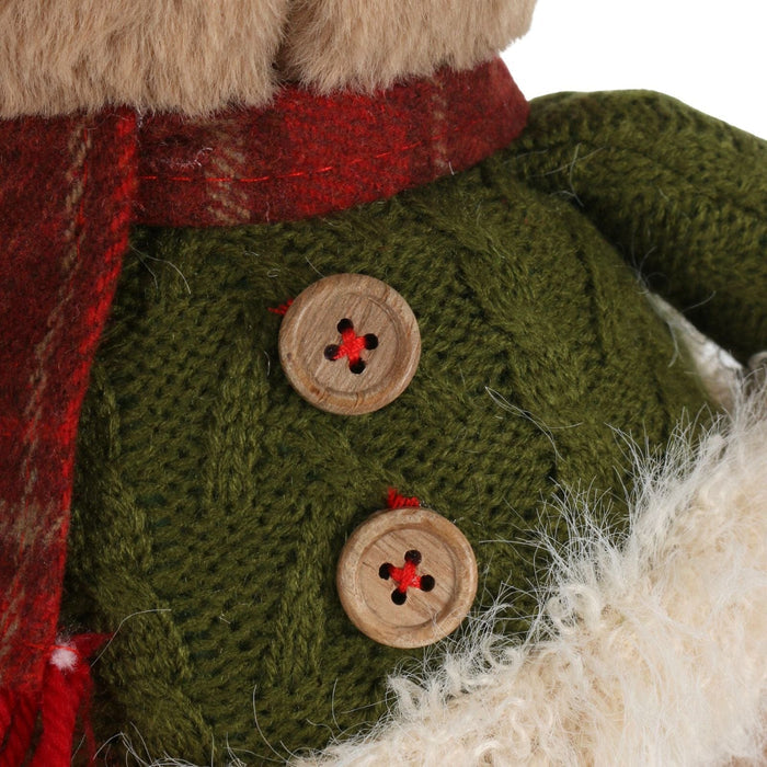 Close-up of a knitted green garment with wooden buttons on a white background