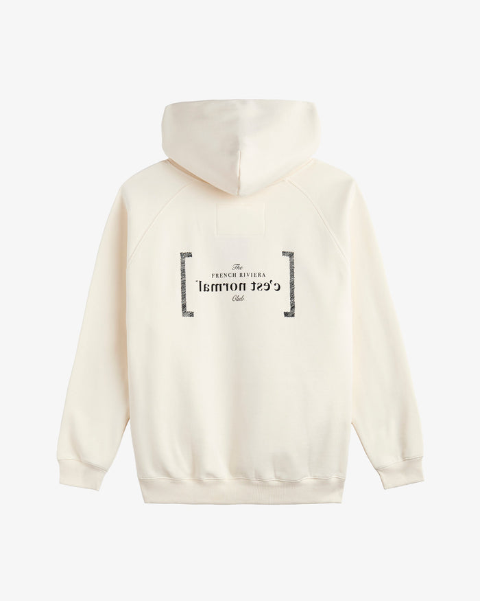 A back view of Le Hoodie in cream, laid flat on a white background. The image highlights the oversized hood, ribbed hem and cuffs, and the black FRC mirror logo and c'est normal text on the center back.