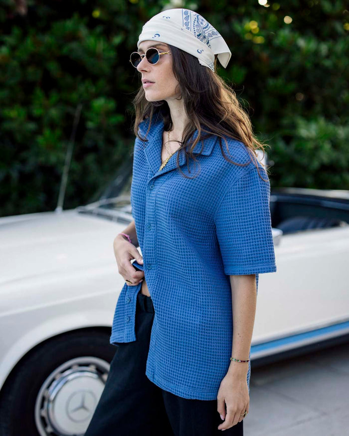 Le Waffle Resort Shirt in azure — worn with a white bandana and sunglasses next to a vintage car