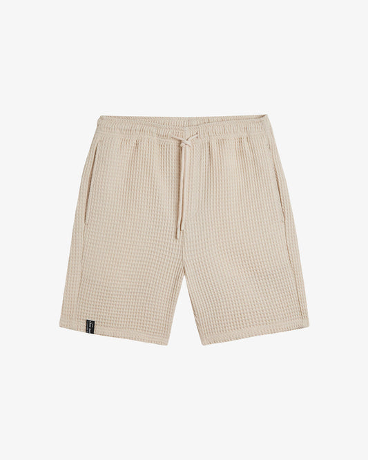Le Waffle Shorts in light beige — front view featuring the waffle texture and drawstring waist