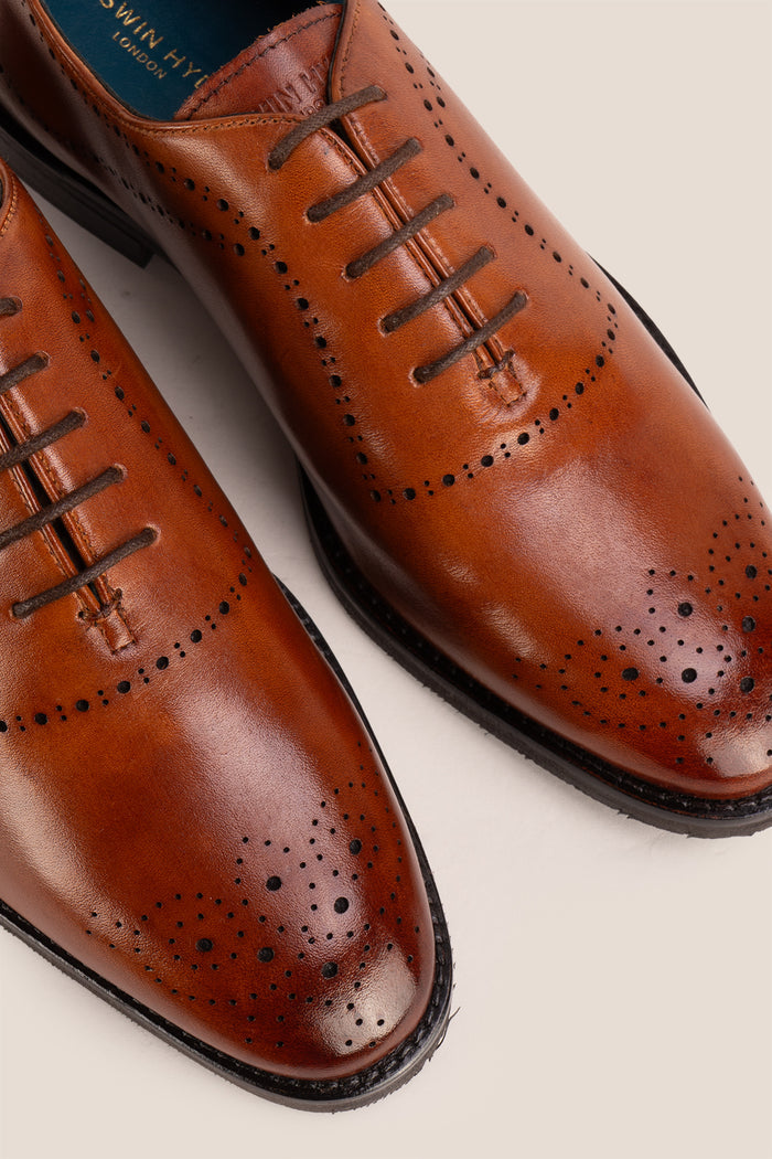 Men’s Melton Oxford shoes in tan leather with classic closed lacing and elegant detailing, perfect for formal and refined dress codes.