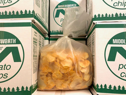 A clear plastic bag filled with BBQ flavored Middleswarth potato chips, placed inside a green and white cardboard box.