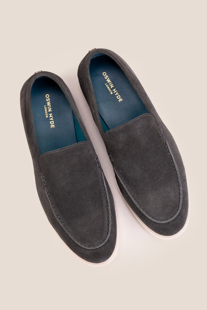Top-down view of Oswin Hyde Morgan grey suede loafers, highlighting the teal blue inner lining and gold logo branding.