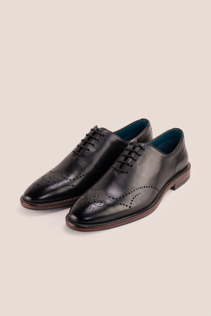 Oswin Hyde London premium black leather wingtip brogues with a toe medallion pattern, contrast welt stitching, and a cushioned teal interior.