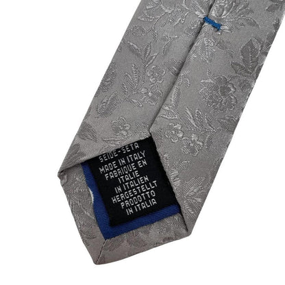 Paul Smith silver silk tie with floral print and brand logo detail.