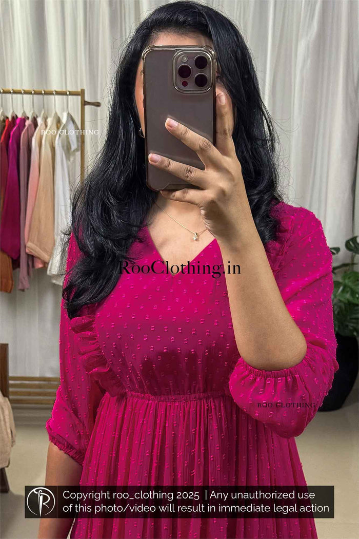 Woman wearing fuchsia pink chiffon midi dress with v-neckline, balloon sleeves, empire waist, and tiered hem – Roo Clothing