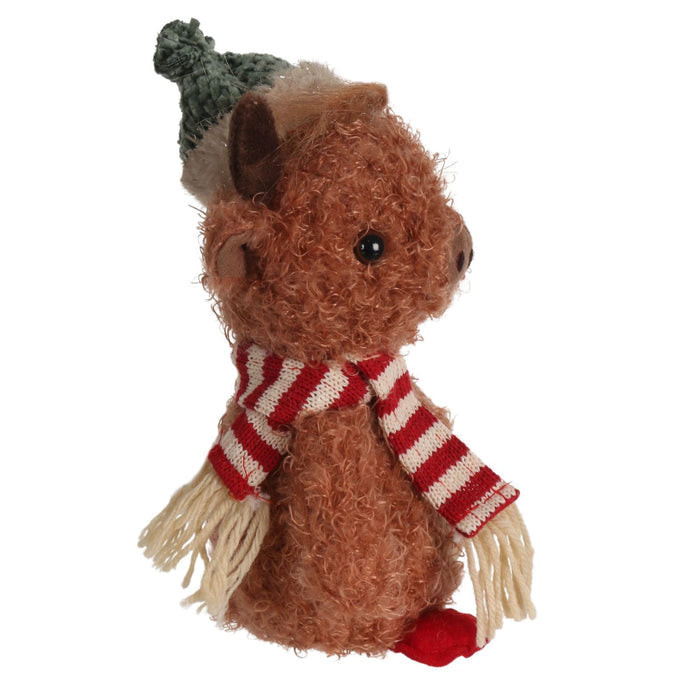 side view of highland cow plush decoration wearing striped scarf and green hat