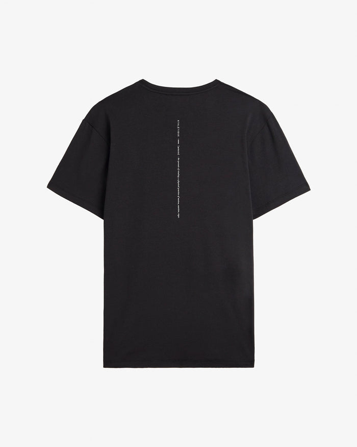 A back view of The Athlétique Tee in black, laid flat on a white background. The image highlights the relaxed fit and the vertical Athlétique text printed down the center of the back.