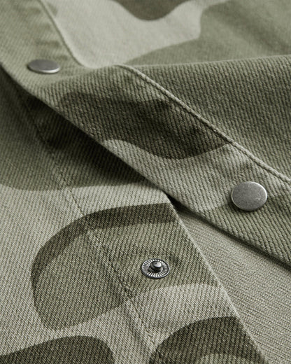 The Bilbao Overshirt in camo — close-up of the metal snap buttons and twill texture