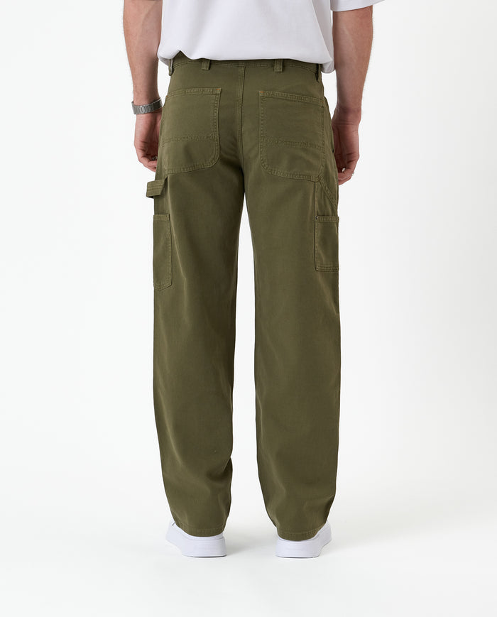 The Carpenter Pant in olive green — back view showing utility pockets and a hammer loop