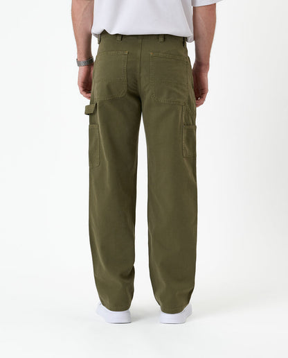 The Carpenter Pant in olive green — back view showing utility pockets and a hammer loop
