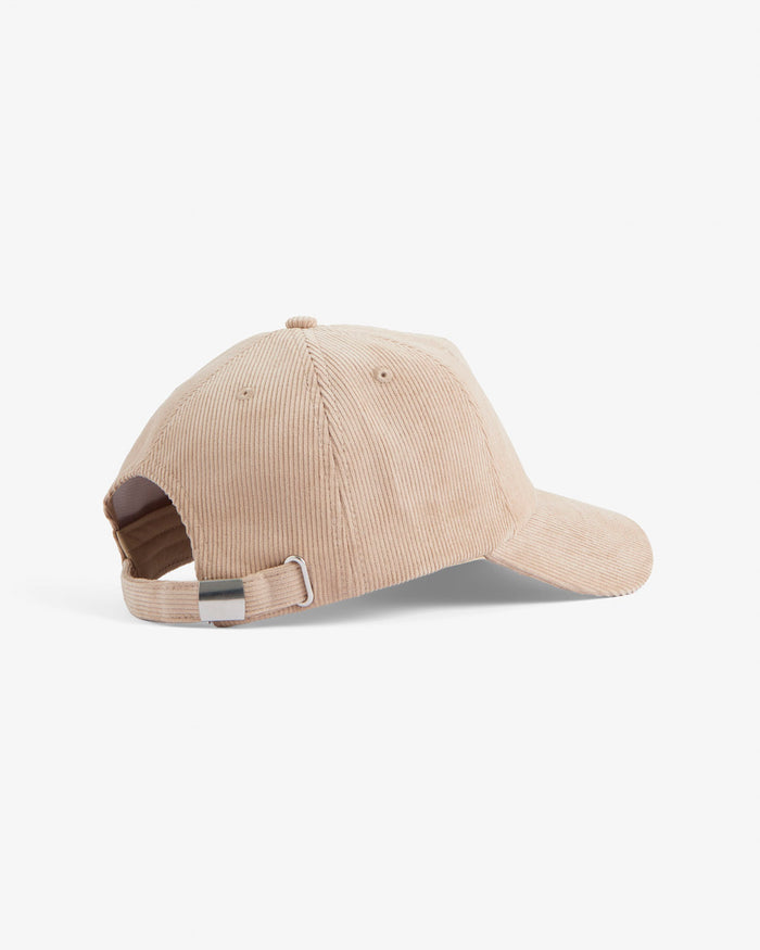 A back view of The CÔTELÉ Corduroy Cap in Irish Cream, laid flat on a white background. The image highlights the corduroy texture and the adjustable strap with a metal buckle.