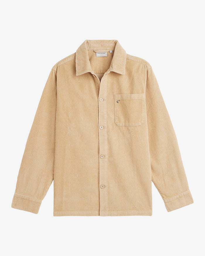 A front view of The CÔTELÉ Corduroy Overshirt in Irish Cream, laid flat on a white background. The image highlights the button-down front, chest pocket with a small c'est normal logo, and the corduroy texture.