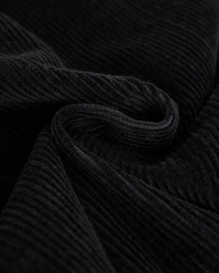 A close-up shot of the mid wale corduroy fabric of The CÔTELÉ Corduroy Straight Pants in anthracite grey, highlighting its soft, ribbed texture.