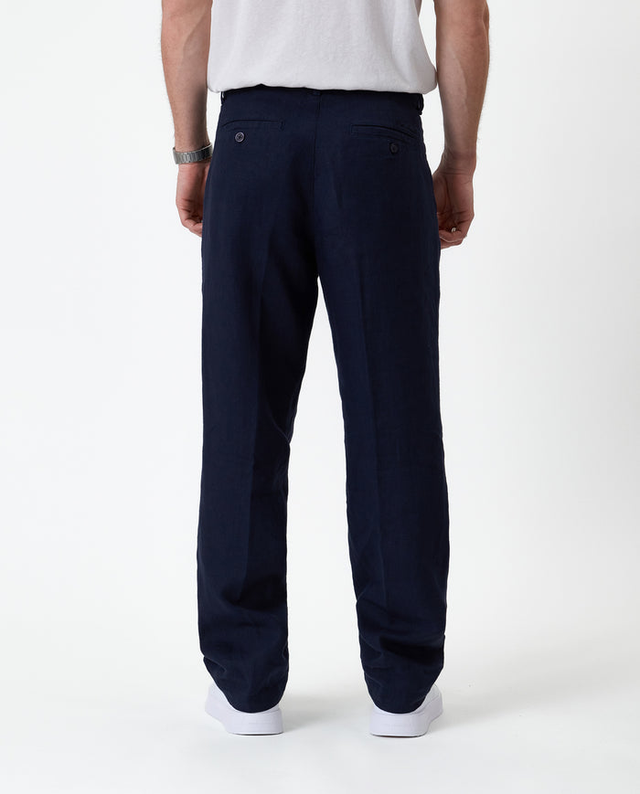 The Daily Linen Trouser in navy — back view showing the welt pockets and pressed crease