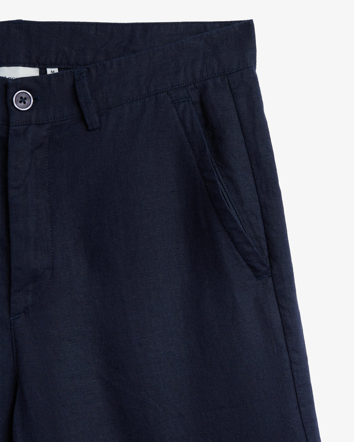 The Daily Linen Trouser in navy — close-up of the waistband and slanted front pocket