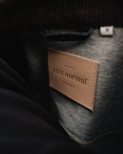 The Denim Jacket in rinse — close-up of the C'est normal neck label