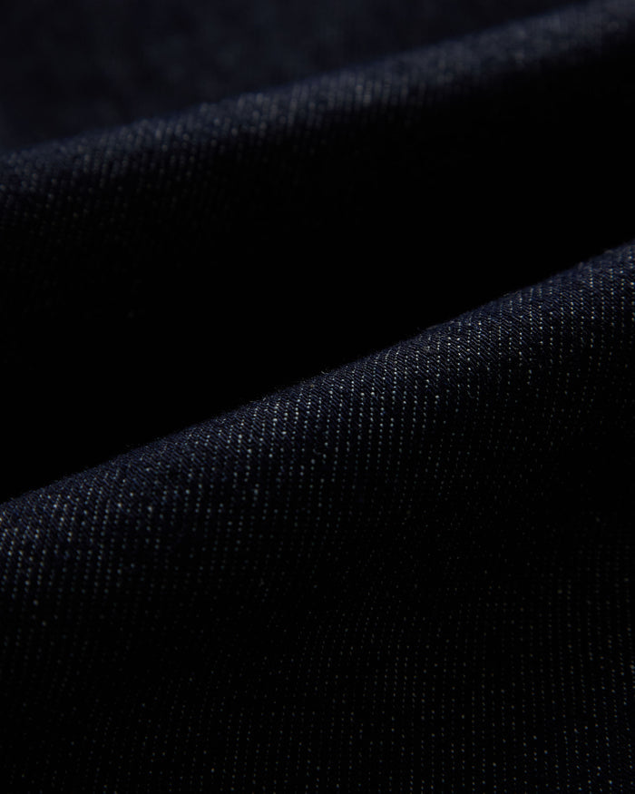 The Denim Jacket in rinse blue — close-up of the stretch motion denim fabric