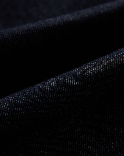 The Denim Jacket in rinse blue — close-up of the stretch motion denim fabric