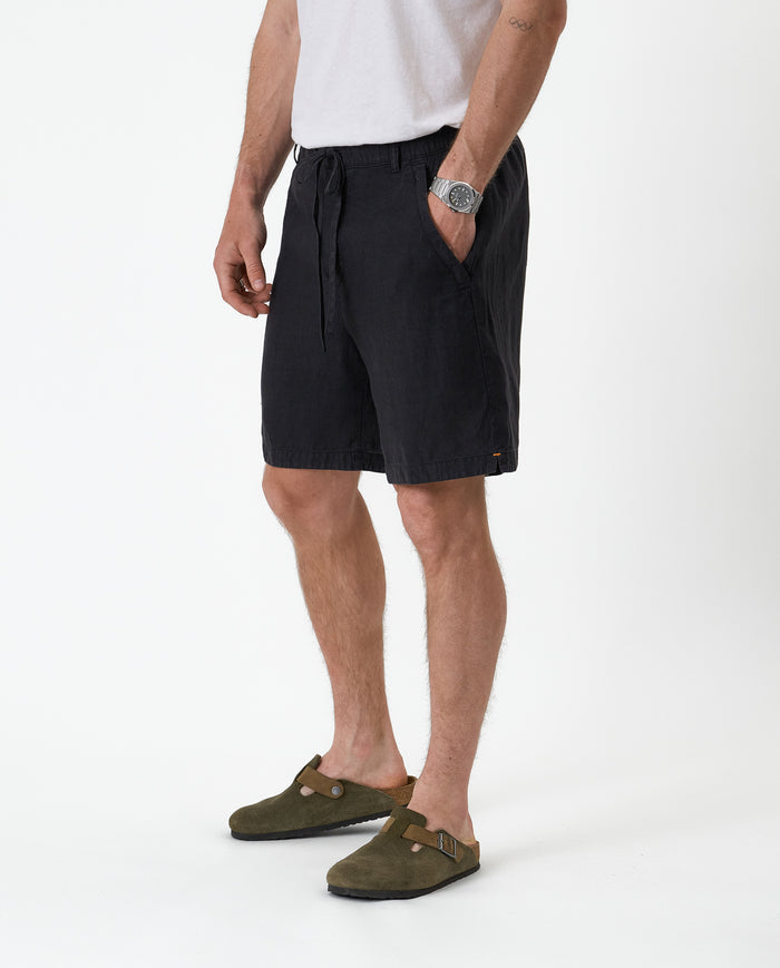 The Holiday Linen Short in black — side view showing the drawstring waist and side pockets