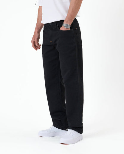 The Jeans Relaxed Straight Fit in jet black — side view worn with white sneakers