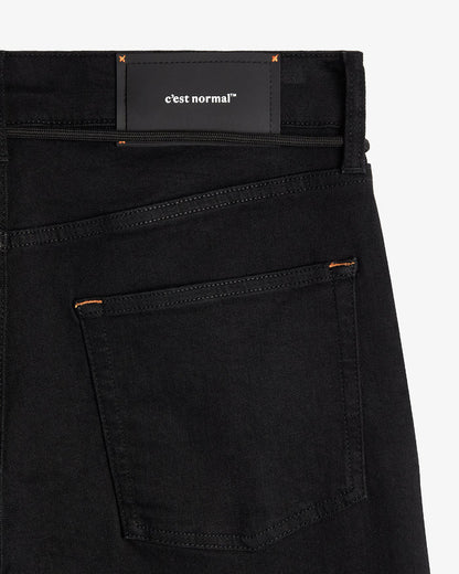 The Jeans Relaxed Straight Fit in jet black — back view with the black C'est normal rubber patch