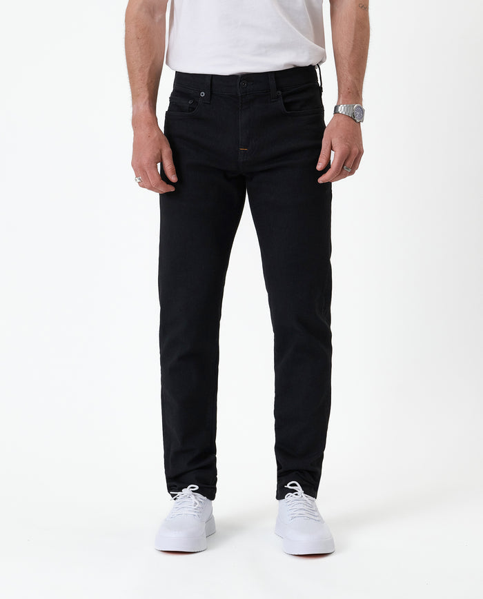 The Jeans Slim Fit in jet black — front view worn with white sneakers