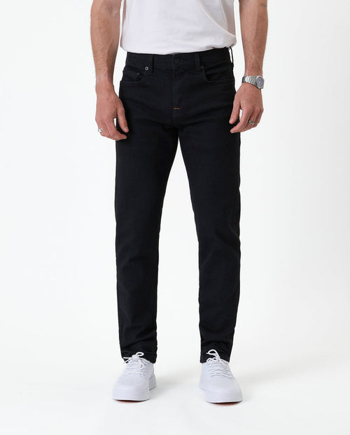 The Jeans Slim Fit in jet black — front view worn with white sneakers