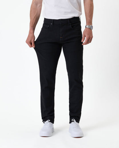 The Jeans Slim Fit in jet black — pulling the fabric to demonstrate the Motion Fabric stretch