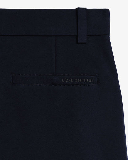 The Proper Pant Relaxed Straight Fit in navy — close-up of the back welt pocket with C'est normal logo
