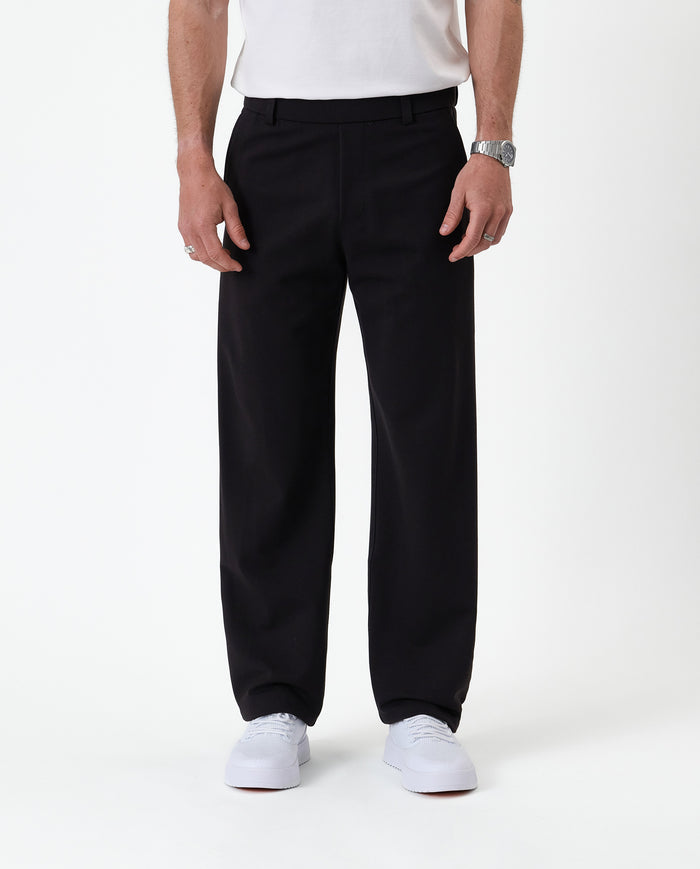 The Proper Pant Relaxed Straight Fit in black — front view worn with white sneakers