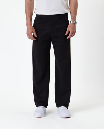 The Proper Pant Relaxed Straight Fit in black — front view worn with white sneakers