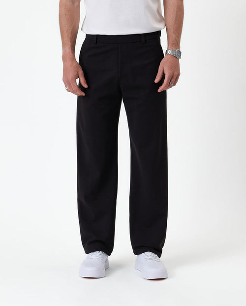 The Proper Pant Relaxed Straight Fit in black — front view worn with white sneakers