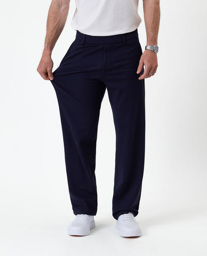 The Proper Pant Relaxed Straight Fit in navy — pulling the fabric to show its stretch