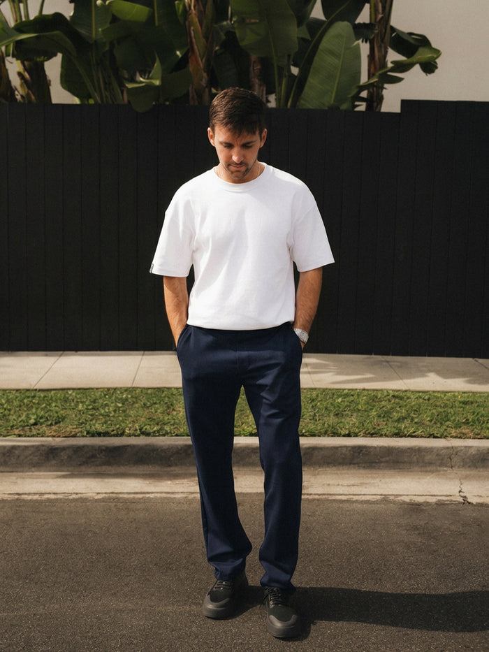 The Proper Pant Relaxed Straight Fit in navy — worn with a white t-shirt and black sneakers