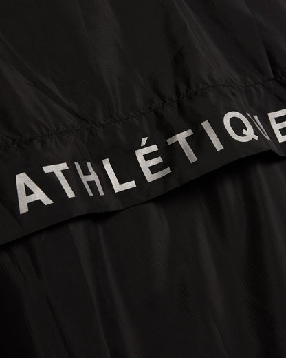 A close-up shot of The Running Jacket in black, highlighting the reflective ATHLÉTIQUE branding across the back ventilation panel.