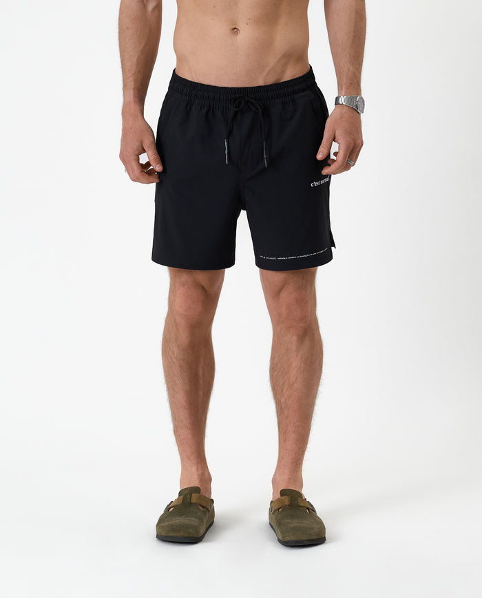The Shorts in black — front view featuring the white C'est normal logo