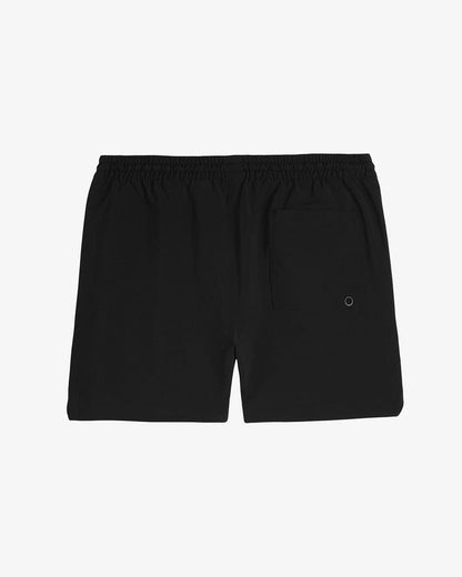 A back view of The Shorts in black, laid flat on a white background. The image highlights the elasticated waistband and the back pocket with a small detail.