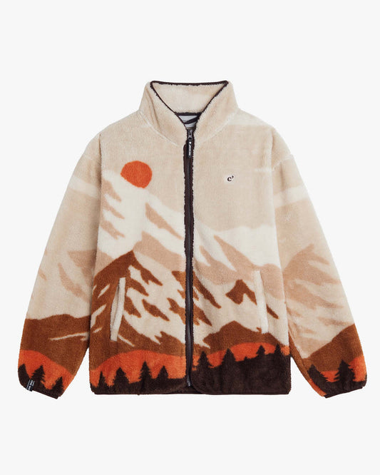 A flat lay of The Wilderness Jacket on a white background. The multicolor fleece jacket features a full-zip front, a high collar, and a mountain landscape pattern in shades of beige, brown, and orange, with the c'est normal 'c' logo embroidered on the chest.