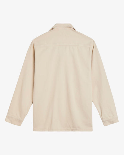 A back view of The Workwear Overshirt in cream, laid flat on a white background. The image highlights the tone on tone c'est normal branding on the upper back.