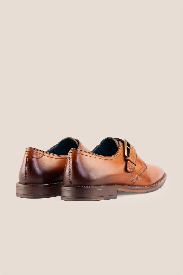 Premium men's tan leather single monk strap dress shoes by Oswin Hyde London featuring a plain toe, adjustable golden buckle, contrast sole stitching, and a cushioned teal interior.